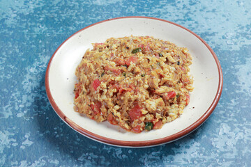 presenting barbeque of brinjal with chopped onions, chilies, tomatoes and fried eggs with mustards oil and salt