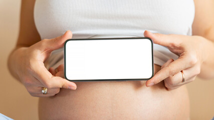 Pregnancy mockup display. Pregnant woman holding smartphone. Mobile pregnancy online maternity application mock up. Concept maternity, pregnancy, childbirth.