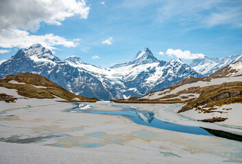Landscape of Bachalpsee lake, covered by ice. Highest peaks Eiger, Jungfrau and Faulhorn in famous...