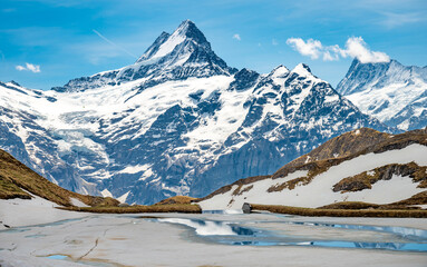 Landscape of Bachalpsee lake, covered by ice. Highest peaks Eiger, Jungfrau and Faulhorn in famous location.  Grindelwald, Switzerland Alps.