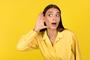 Curious Millennial Woman Listening Secrets Eavesdropping Posing Over Yellow Background