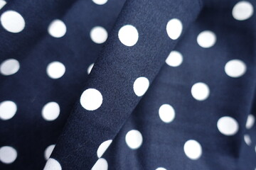 dark blue and white cotton fabric with polka dot pattern in soft folds