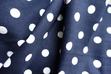 Rumpled dark blue and white cotton fabric with polka dot pattern