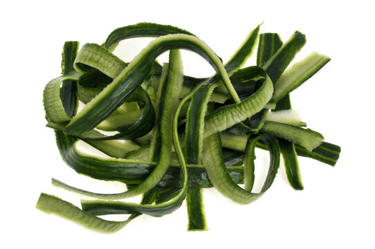 Des &eacute;pluchures de concombre en gros plan sur fond blanc