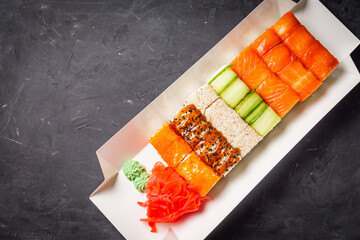 delicious sushi rolls in a delivery box on a black background
