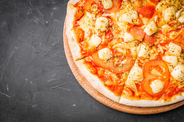 hot delicious traditional italian pizza on a dark stone background