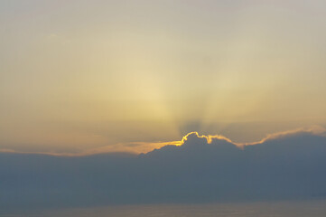 Evening sunset with sun rays through the clouds over the sea