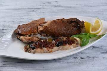 Beluga fillet in a salt crust with sun-dried tomatoes and olives on fire