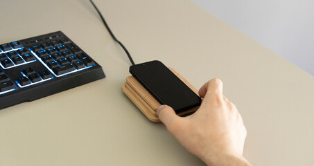 hand holding a smartphone and put it on the wireless power charger