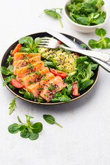 Salmon fish fillet with fresh salad, avocado top view.