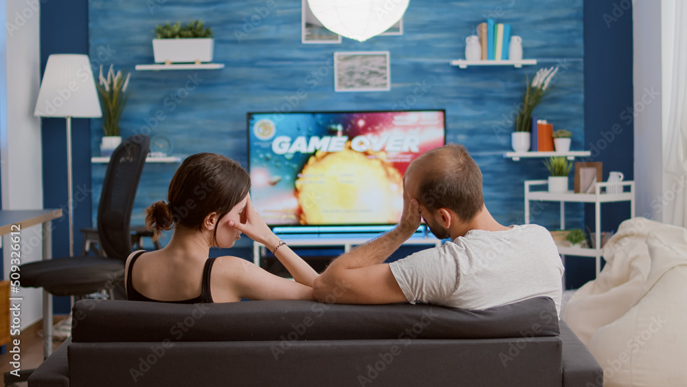 Poster couple disappointed because of losing online console space shooter while playing using wireless cont