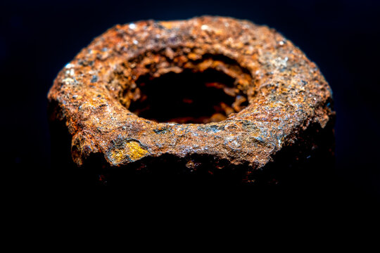 Close-up of a very old, rusty nut. Selective focus with strong blur.