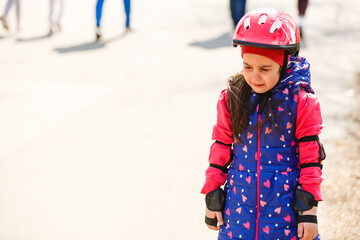 Girl with helmet on but without protective knee pads crying