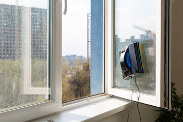 Robot window cleaner work on dirty window. Cleaning the house with smart devices. Automatic vacuum...