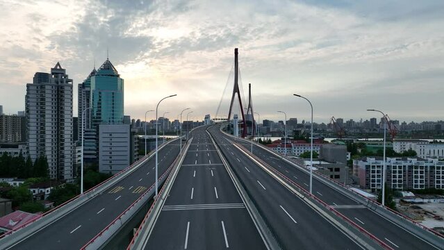 Drone aerial view of Traffic and highway in the city during sunset. Drone flying over bridge during covid-19 lockdown in Shanghai China.  Business, travel and health care concept b-roll footage.