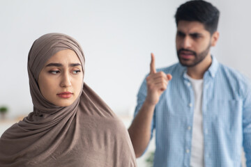 Angry Husband Shouting At Unhappy Muslim Wife Standing At Home