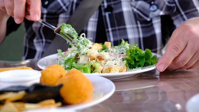 Senior woman  eating  healthy salad in cafe. Green healthy food concept. Mixed green salad with grilled chicken and croutons