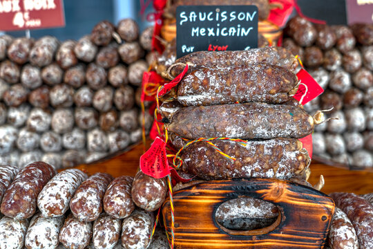 Stacks of various kinds of saucisson or saucisson sec - dry-cured sausages, typically made of pork, or a mixture of pork and other meats. 