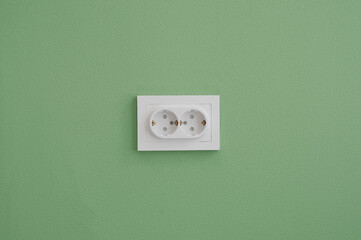 Electrical outlet in the green wall background
