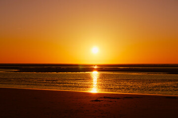 Golden sky and sunset over sea and horizon.