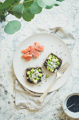 Healthy breakfast with salmon and toasts with rye bread, avocado and blue cheese
