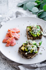 Healthy breakfast with salmon and toasts with rye bread, avocado and blue cheese