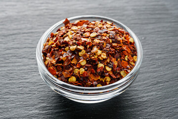 spicy chili flakes on a dark stone background