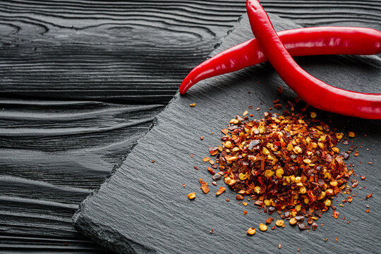 spicy chili flakes on a dark stone background