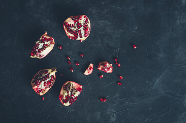Fototapeta premium Red juicy pomegranate on dark background. Copy space.
