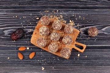 Healthy homemade sweets on dark wooden table, top view. Energy balls are a healthy snack. Balls of...