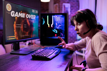 Frustrated woman losing video games tournament on pc, feeling sad about lost shooting gameplay...