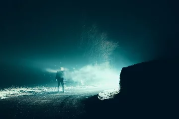 Papier Peint photo UFO Un concept d& 39 horreur et de science-fiction. D& 39 un homme qui disparaît en fumée devant de mystérieuses lumières brillantes. Sur une route de campagne effrayante par une nuit d& 39 hiver brumeuse.