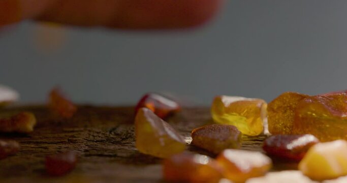 Natural amber Stone falling on a wooden plate