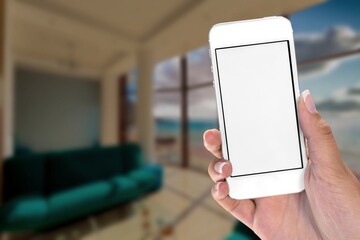 Smart home concept.  Woman holding mobile phone on home interior background. Internet of things, comfort in house