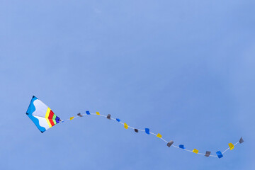Colorful kite fly in the blue sky. Copy space. Positive freedom concept.  Happy carefree childhood.