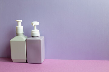 Plastic shampoo bottles on purple table. purple wall background