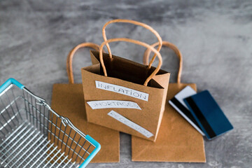 economy after covid, inflation shortages and recession texts on shopping bag with cart and payment...
