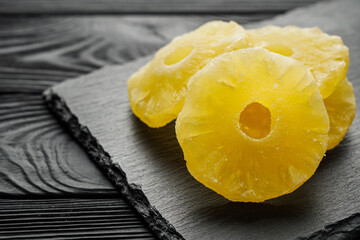 delicious dried pineapple on a black wooden rustic background