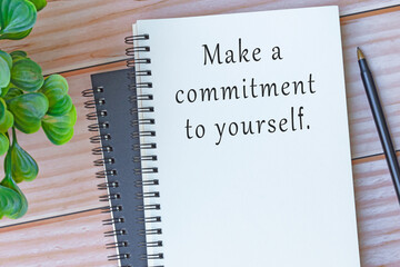 Motivational and inspirational quote on note book on wooden desk .