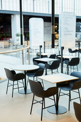 Minimal background image of minimal food court interior in black and white with tables and chairs in row, copy space