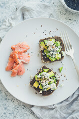 Healthy breakfast with salmon and toasts with rye bread, avocado and blue cheese