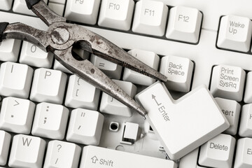Pliers with ENTER key laying on the keyboard