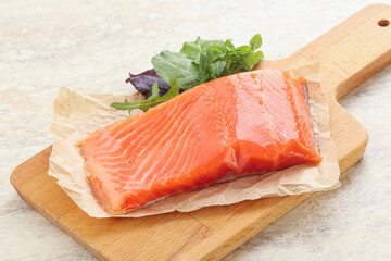 Raw salmon fillet over board
