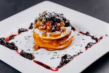 Delicious Pancakes are served with currant jam and apples on a plate ready for eat