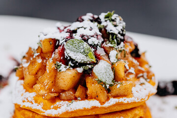 Delicious Pancakes are served with currant jam and apples on a plate ready for eat