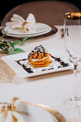 Delicious Pancakes are served with currant jam and apples on a plate ready for eat