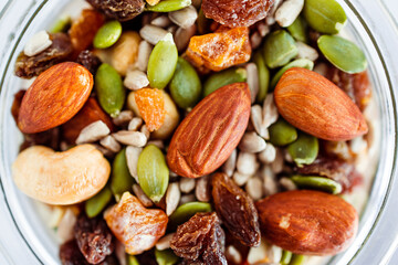 glass jar of mixed nuts including almonds cashews and pistachios, natural healthy pantry ingredients
