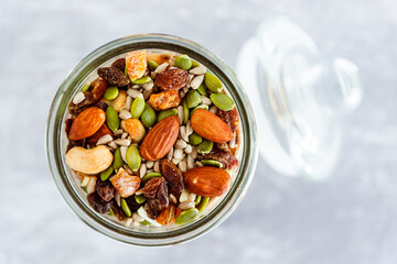 glass jar of mixed nuts including almonds cashews and pistachios, natural healthy pantry ingredients