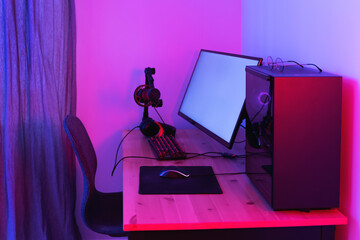 Gaming personal computer and ultrawide monitor in neon light