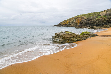 Beautiful beach landscape with sand and rocks by the ocean. Sea landscape, turquoise water and beach.
